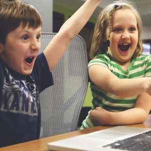 un-garçon-et-une-fillette-heureux-font-hourra-devant-un-écran-ordinateur